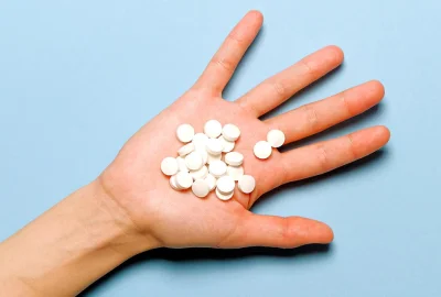Mehrere runde Tabletten liegen auf einer offenen Handfläche