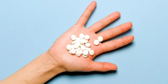 Mehrere runde Tabletten liegen auf einer offenen Handfläche