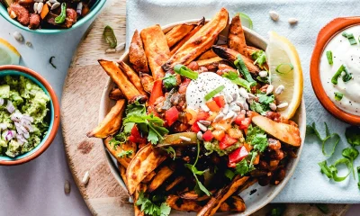 Mehrere Gefäße mit frittierten Kartoffeln und Dips