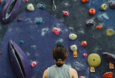 Person blickt eine Kletterwand hinauf
