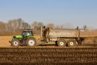 Traktor auf auf Feld mit Güllewagen