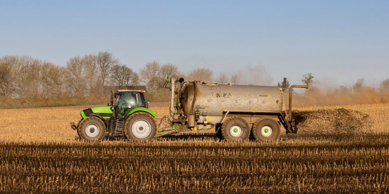 Traktor auf auf Feld mit Güllewagen