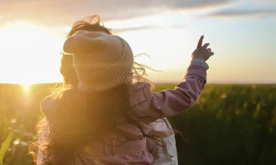 Frau mit Kind im Arm auf Feld