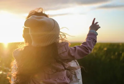 Frau mit Kind im Arm auf Feld