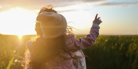 Frau mit Kind im Arm auf Feld