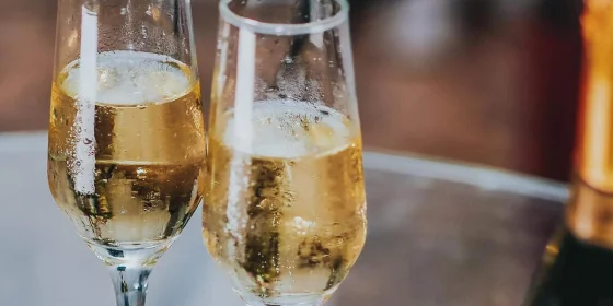 Zwei gefüllte Sektgläser neben einer Flasche
