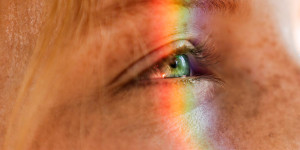 Ein buntes Farbspektrum über der Großaufnahme eines menschlichen Auges