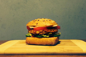 Veganer Burger mit selbstgemachtem Haferflocken-Bratling, Tomate, Zwiebeln und Salat